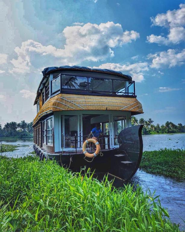 库玛拉孔Grand Villa Houseboat的水中的小船,上面有房子