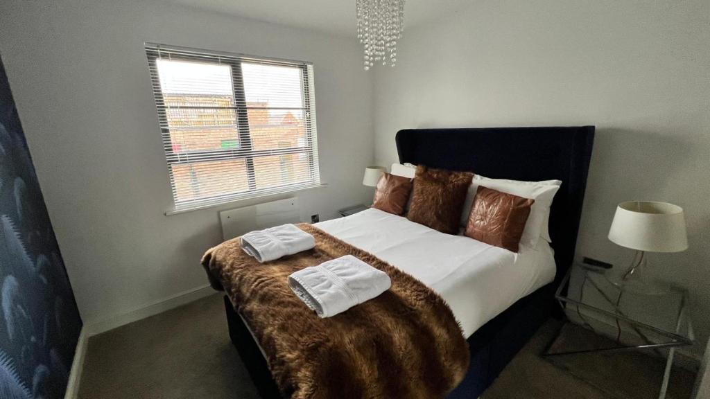 - une chambre avec un grand lit et des oreillers bruns dans l'établissement Stunning Flat in Hull's Vibrant Fruit Market & Marina, à Hull