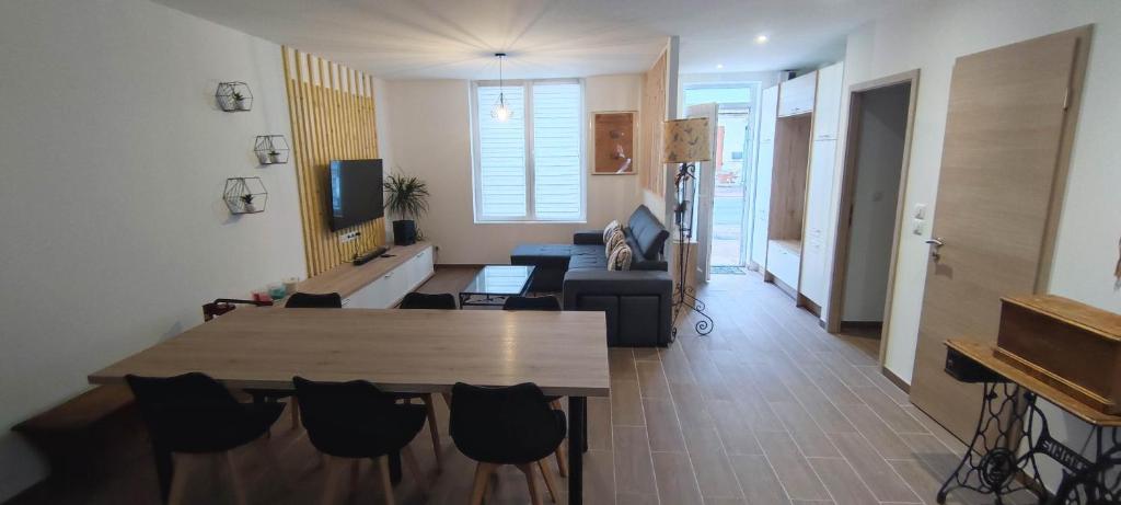 ein Wohnzimmer mit einem Tisch und einem Sofa in der Unterkunft Charmante maison de plain-pied in Rochefort