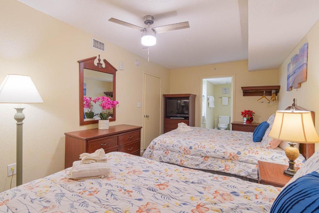 a hotel room with two beds and a mirror at Atlantica Resort in Myrtle Beach
