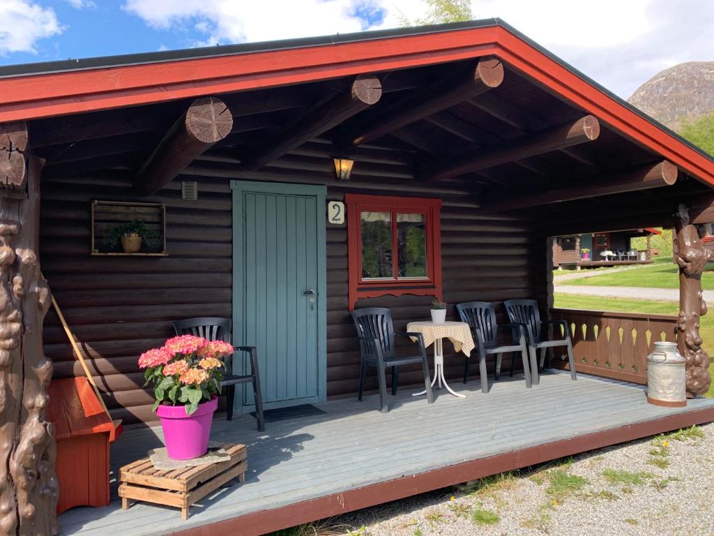 een hut met een terras met stoelen en een tafel bij Åndalsnes Hytteutleie in Veblungsnes