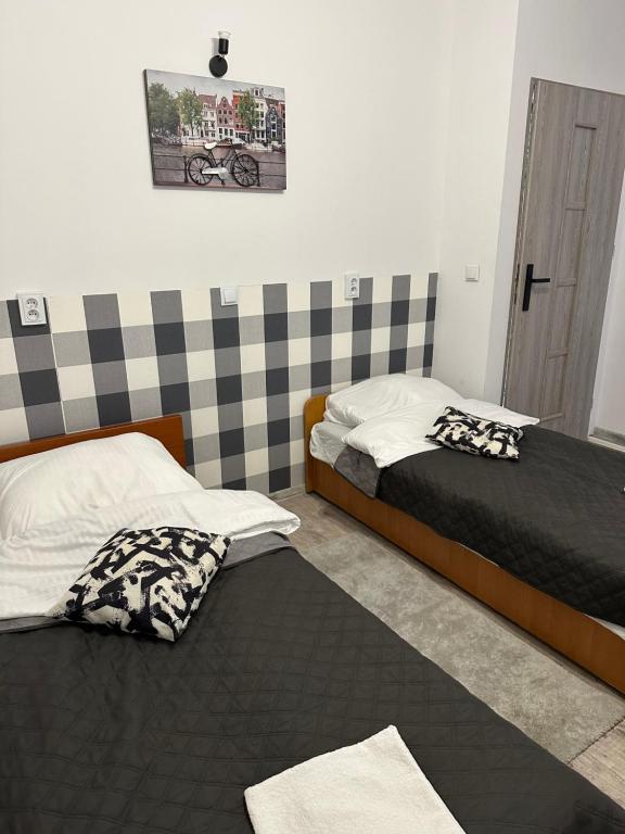 a bedroom with two beds and a door to a room at Apartament przy Sali Kominkowej in Przeczyce