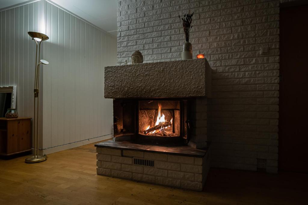 a fireplace in a room with a brick wall at Boukersen Heim in Tromsø