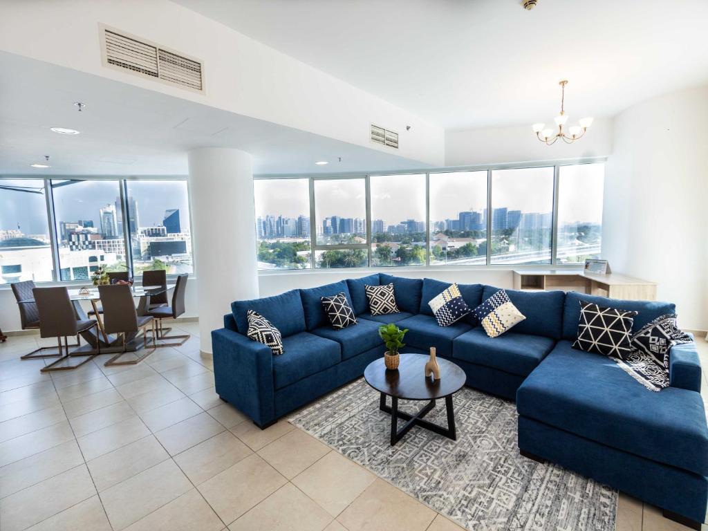 a living room with a blue couch and a table at Avantha By Afi luxury 2BHK apartment in Dubai