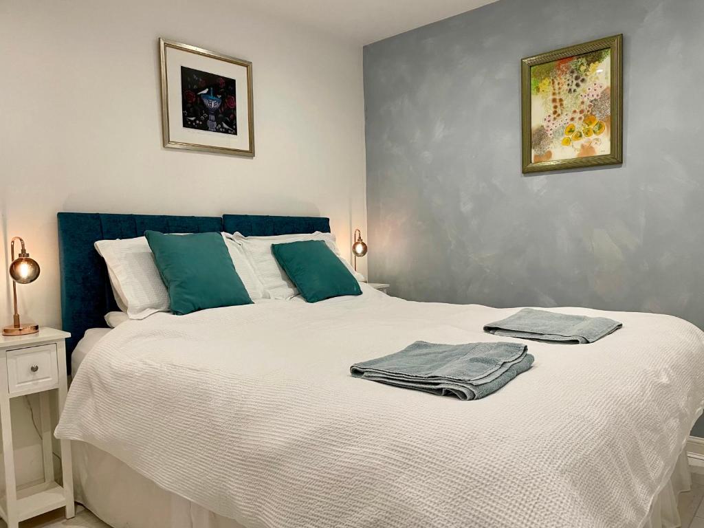 una camera da letto con un grande letto bianco con asciugamani di Saltwater Cottage a Camber