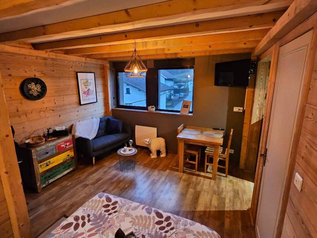 een woonkamer met een bank en een tafel bij Studio type chalet in Gérardmer