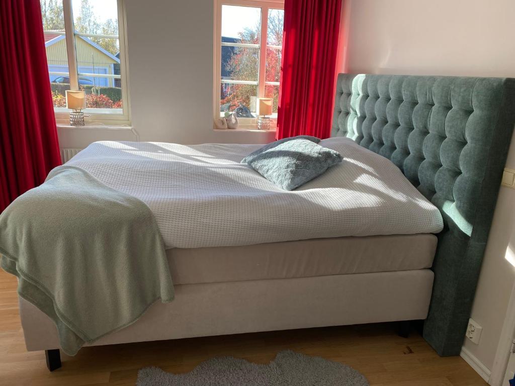 JärnaDR ÅSA Rooms in Kallfors, Järna, south Stockholm, near Golf, Ytterjärna Concerts & the Baltic Sea Beach的卧室内的一张床位,配有红色窗帘