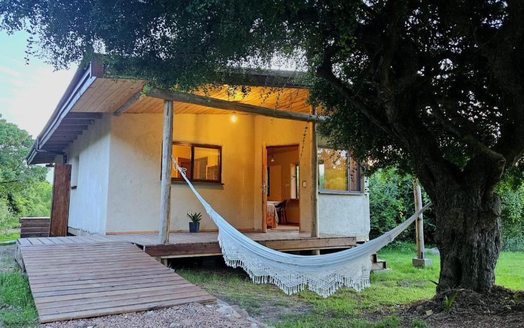 une maison avec un hamac en face de celle-ci dans l'établissement Citrino - Alojamiento Responsable en la naturaleza, à Bella Vista