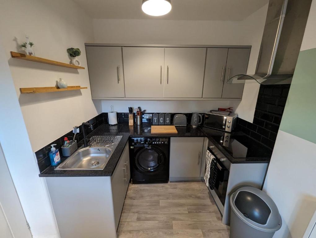 una pequeña cocina con fregadero y lavavajillas en Avon’s Rest en Stratford-upon-Avon