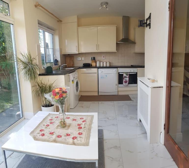 una cocina con una mesa con un jarrón de flores. en 3 Bedroom 3 Bathroom House, Dublin, en Lucan