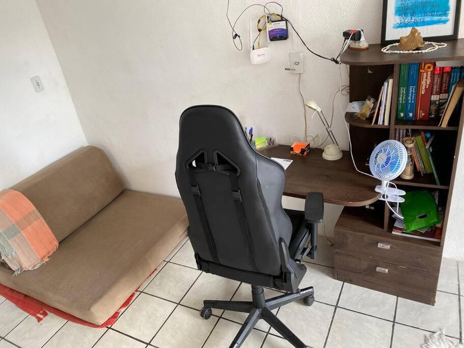 a desk and a chair in a room with a desk and a couch at Casa de Dandá in Porto Seguro