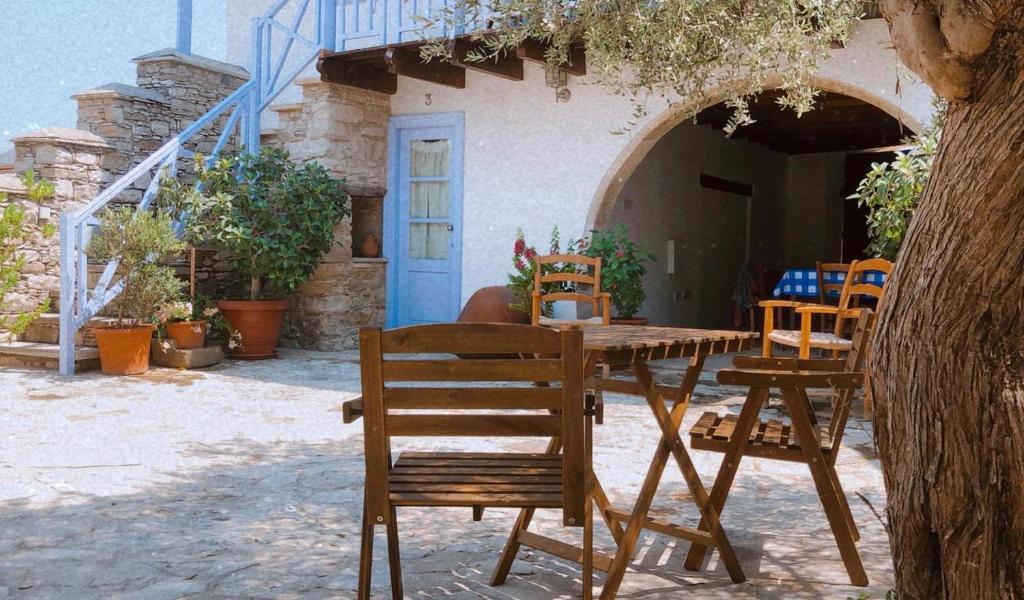 a wooden table and chairs in front of a building at To Konatzi tou Flokka in Ayios Theodhoros