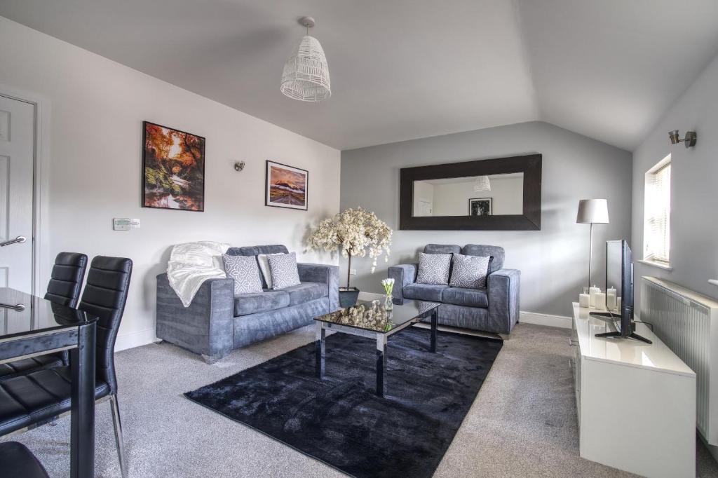 a living room with two couches and a table at #St Georges Court by DerBnB, Spacious 2 Bedroom Apartments, Free Parking, WI-FI, Netflix & Within Walking Distance Of The City Centre in Derby