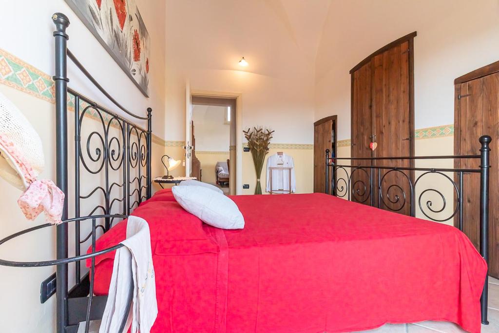 ガリポリにあるAppartamenti in Villa De Santis a Gallipoliの赤いベッド1台(赤い毛布付)が備わるベッドルーム1室が備わります。