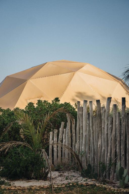 a large tan tent behind a wooden fence at Yogam villa Essaouira in Al Ghar
