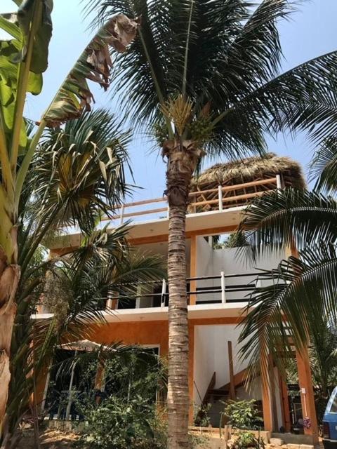 a building with palm trees in front of it at Casa Mañana in Puerto Escondido