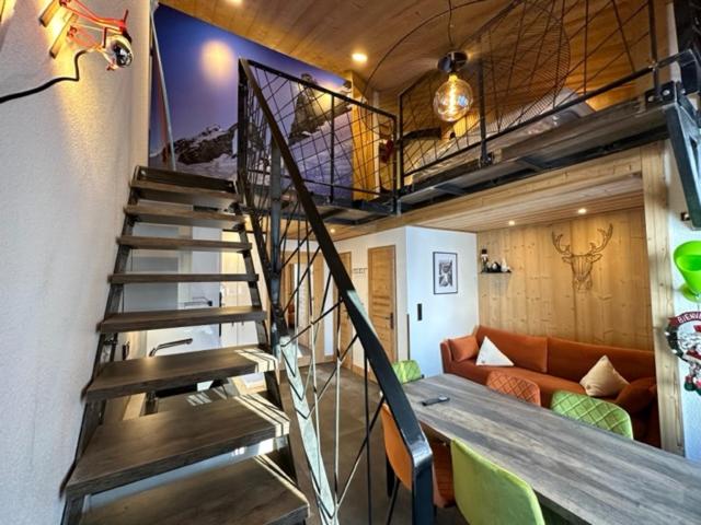 a spiral staircase in a living room with a couch at TIGNES VAL CLARET A LA CONQUETE DES SOMMETS 314 in Tignes