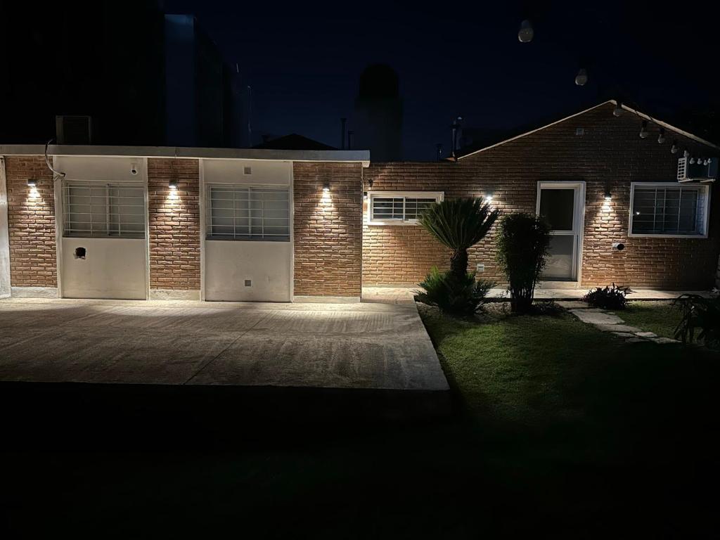 a brick house with white garage doors at night at CASA WRT in Villa Carlos Paz