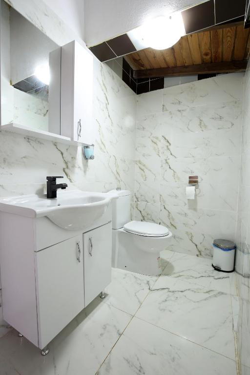 une salle de bain blanche avec un lavabo et des toilettes dans l'établissement Adrasan Shambala, à Adrasan