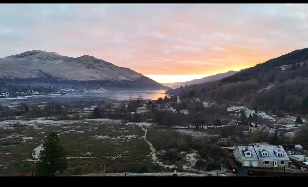 uitzicht op een stad en een meer bij zonsondergang bij Gleann Fia House in Arrochar