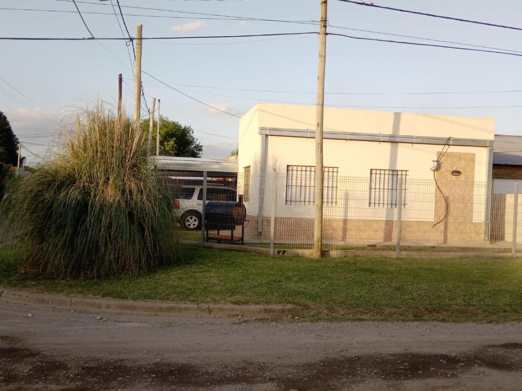 un autobús está estacionado frente a un edificio en Alojamiento Laureant - Capitán Sarmiento - Buenos Aires in 