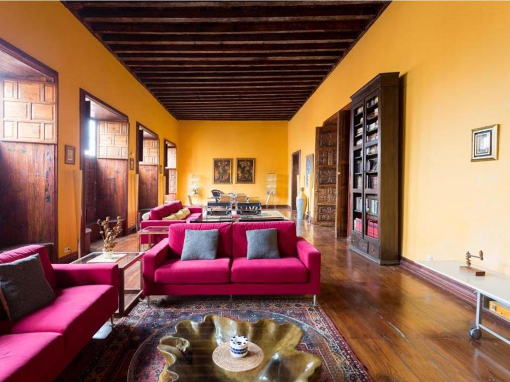 ラ・オロタバにあるLive Orotava Casa antigua Patrimonio nacionalのリビングルーム(ピンクのソファ、テーブル付)
