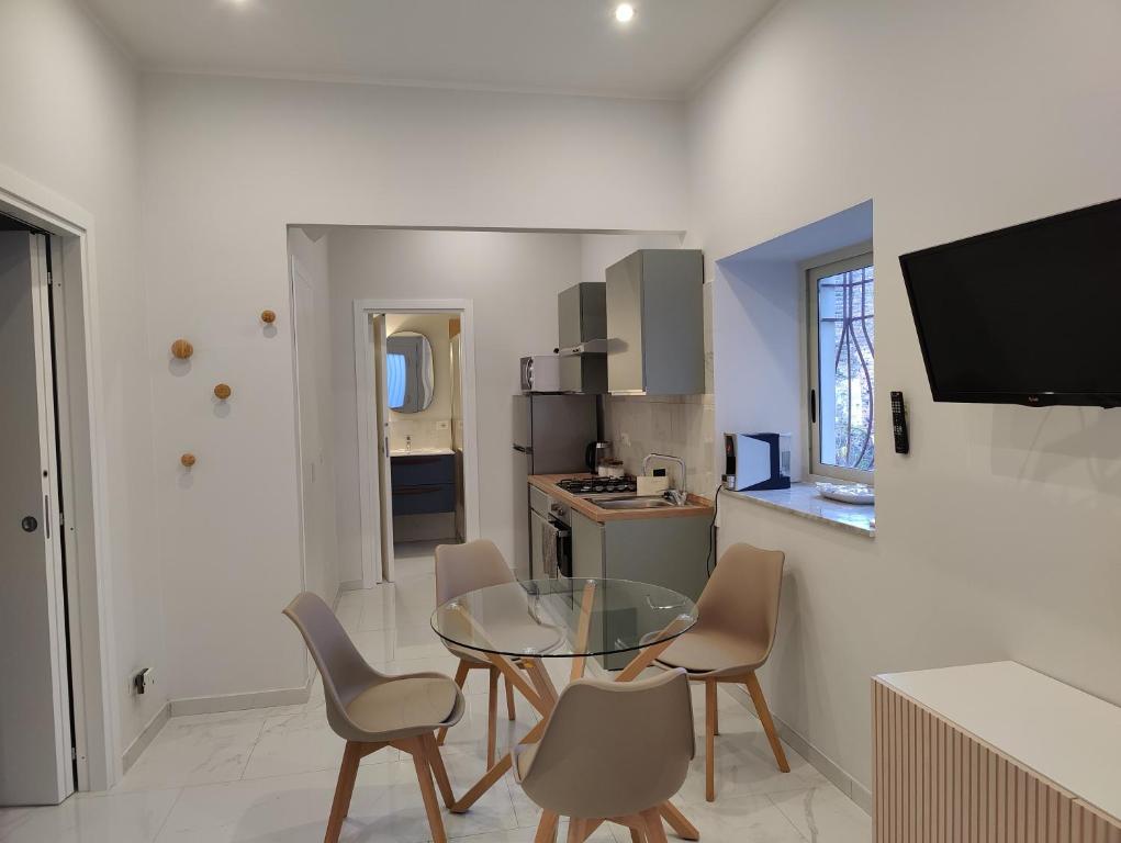 kuchnia ze szklanym stołem i krzesłami w pokoju w obiekcie Cuttigghiu Holiday Apartment w Katanii
