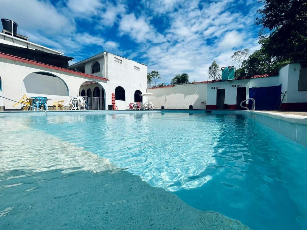 a swimming pool with blue water in front of a building at HOTEL GIRASOL in Carmen de Apicalá