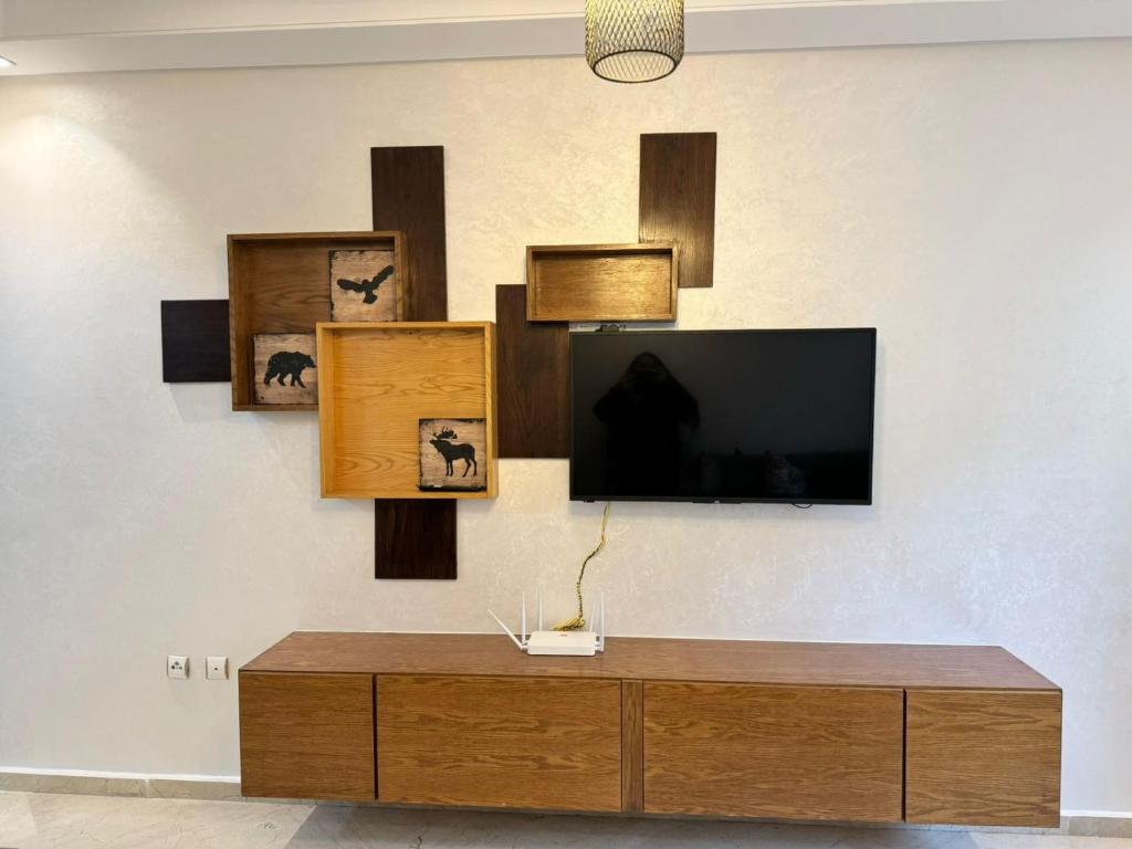 a living room with a tv on a wall at Studio cozy totalement refait avec toutes les commodités necessairessitué au parc de Mohammedia in Mohammedia