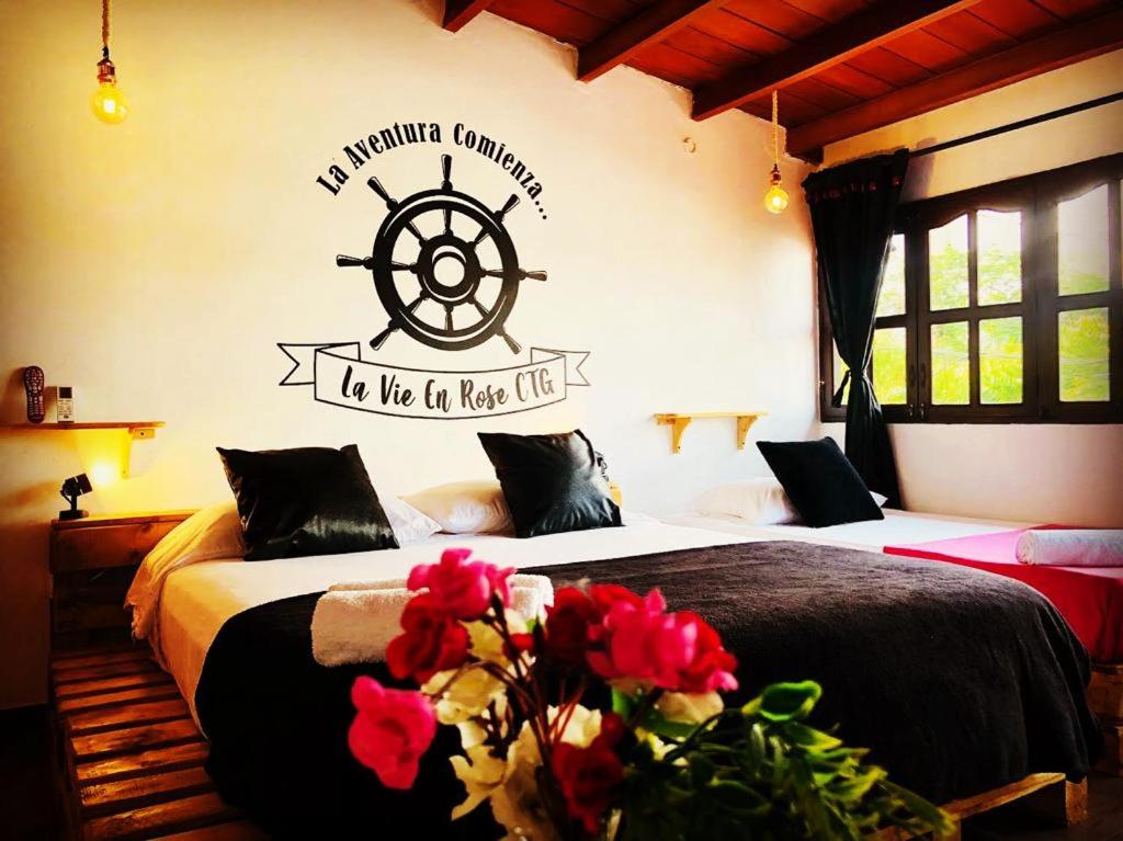 1 dormitorio con 2 camas y un cartel náutico en la pared en Habitacion en La Vie en Rose en Cartagena de Indias