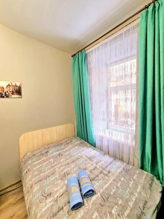 - un lit avec 2 oreillers devant une fenêtre dans l'établissement Студіо Філатова 8, à Lviv