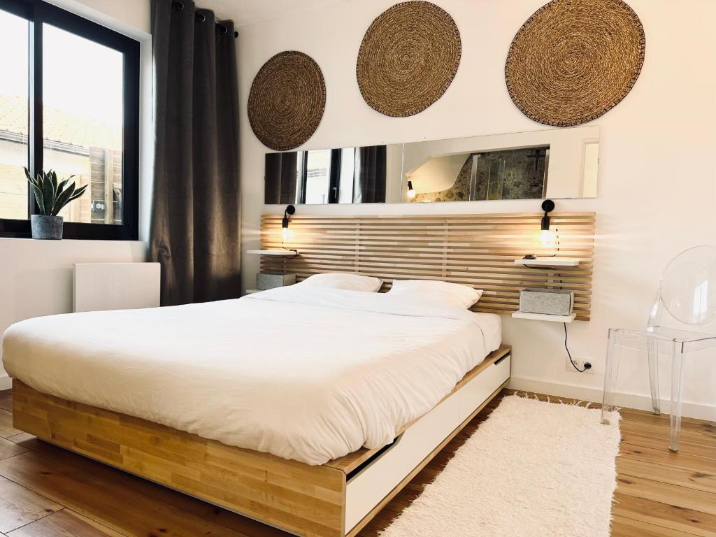 een slaapkamer met een groot bed en een raam bij Villa Ô Wood & Chic in Cucq