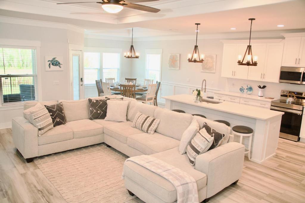 a living room with a white couch and a kitchen at Peaceful Shores Retreat in Panama City Beach