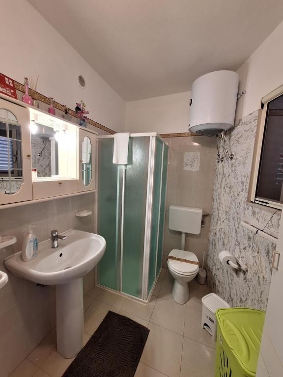 La salle de bains est pourvue d'une douche, d'un lavabo et de toilettes. dans l'établissement A Casa da Nonna Brasa Holiday Home Savoca, à Savoca