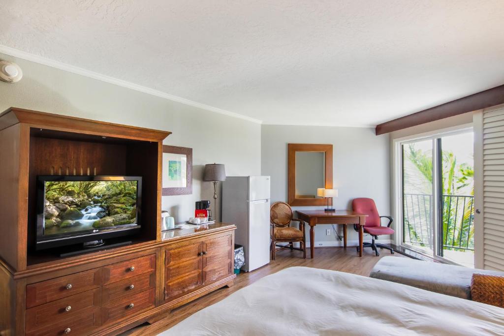 a bedroom with a television on a wooden dresser at Kauai Beach Resort Room 2401 in Lihue