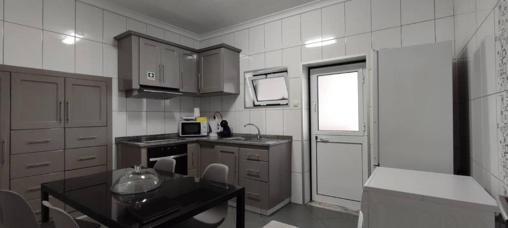 une cuisine avec une petite table et une cuisine avec une fenêtre dans l'établissement Apartamento da Matilde, à Santa Cruz das Flores