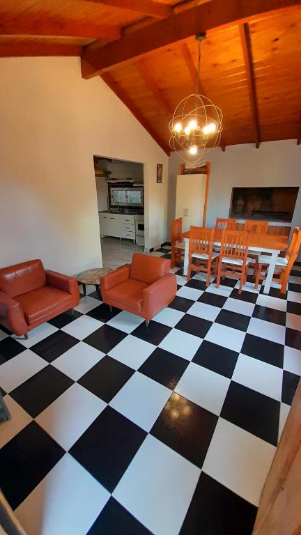 ein Wohnzimmer mit einem schwarz-weiß karierten Boden in der Unterkunft Casa Azul a 5 cuadras del centro y a 8 del mar in Villa Gesell