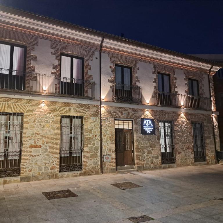 ein Backsteingebäude mit einem Schild an der Seite in der Unterkunft Apartamentos turisticos Ávila Puerta de San Isidro 1-4 in Avila