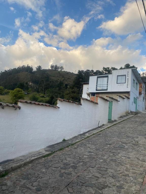 un edificio bianco con finestre sul lato di una strada di GLL HOTEL a El Cocuy