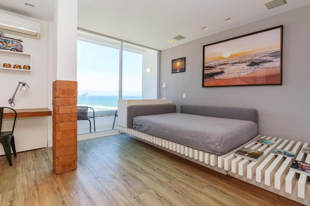 a bedroom with a bed and a desk in a room at Apartamento Barra Beach in Rio de Janeiro