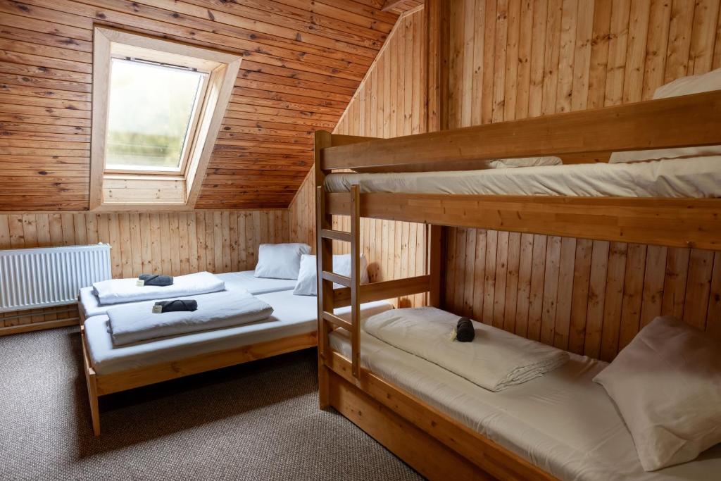 two bunk beds in a cabin with a window at Penzion a Restaurace Kamínek in Doksy