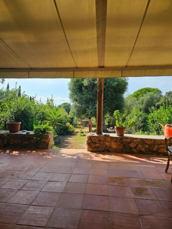an open patio with a stone wall and a chair at Casa in Provinca in Orbetello