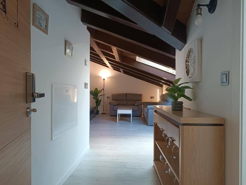 einen Flur mit einem Wohnzimmer mit Sofa und Tür in der Unterkunft Apartamentos turisticos Ávila Puerta de la Santa 2-1 in Avila