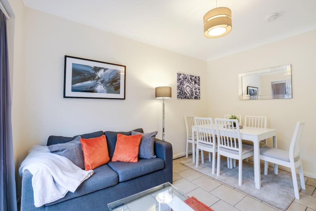 un soggiorno con divano blu e tavolo di 4 Bedroom High Wycombe Home With Free Parking Free WiFi Private Garden - Great Transport Links! a Buckinghamshire