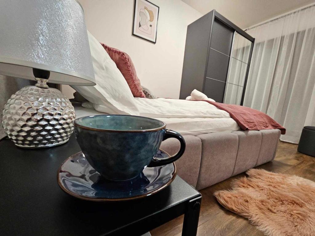 una camera da letto con un letto e un tavolo con una tazza sopra di Apartament Rose, Osada Górska a Szklarska Poręba