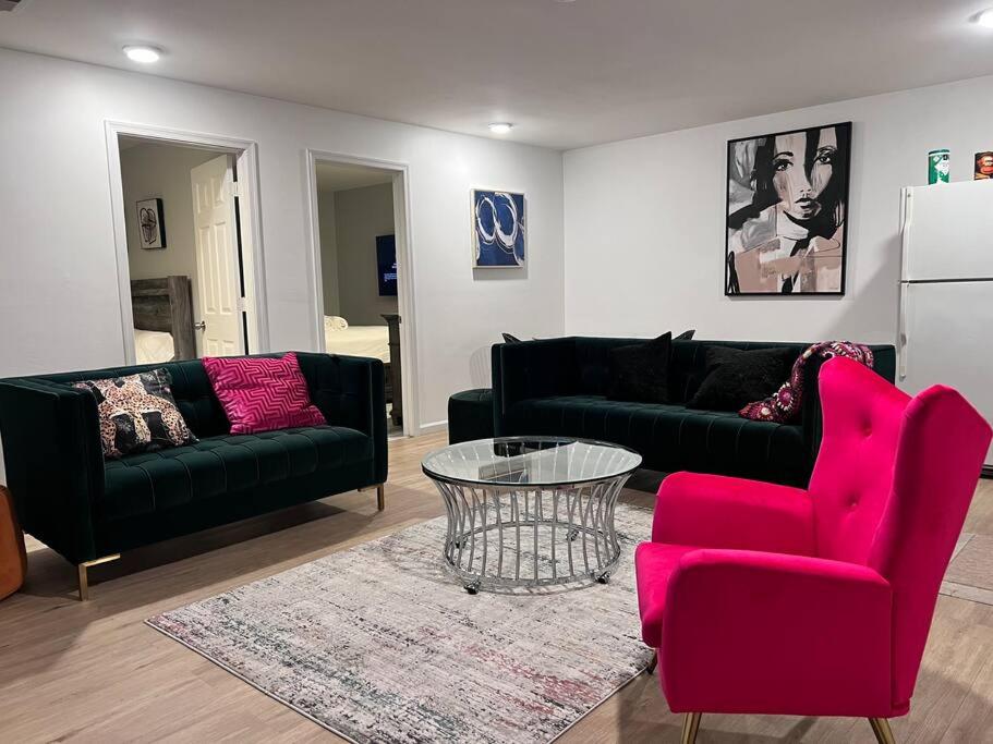 een woonkamer met een zwarte bank en rode stoelen bij Spacious secluded Big 2 Kings near EWR/Newark Downtown in Newark