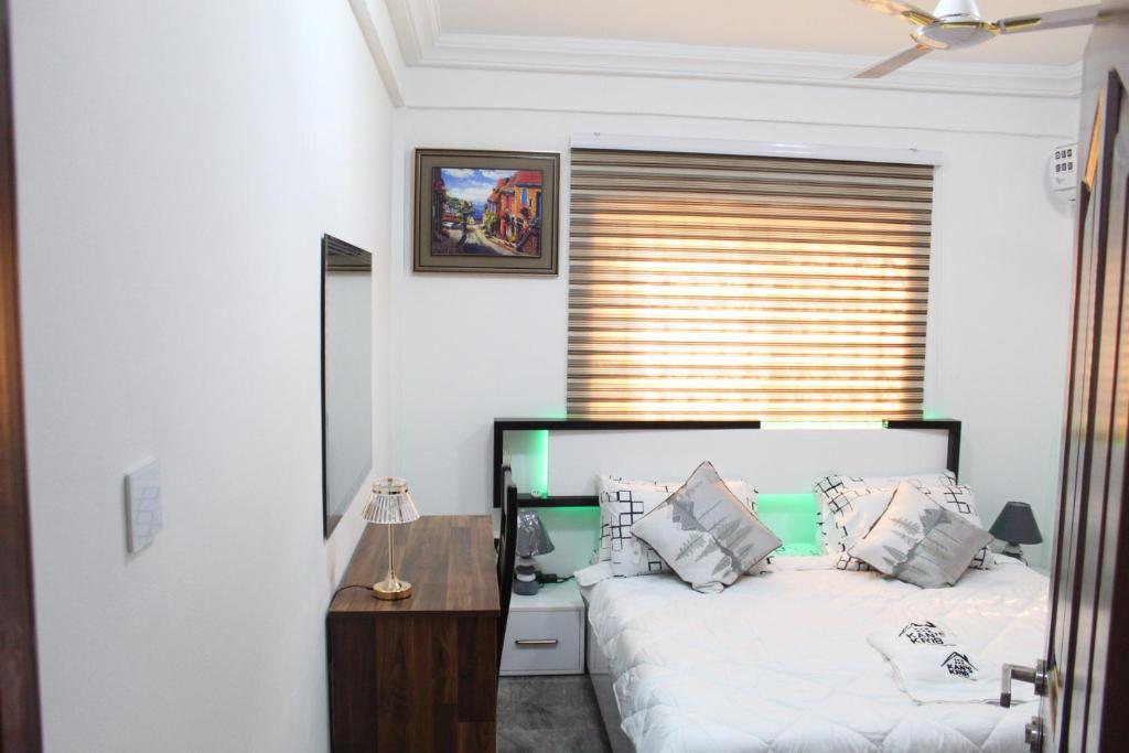 een slaapkamer met een bed, een bureau en een raam bij KANS KRIB in Accra