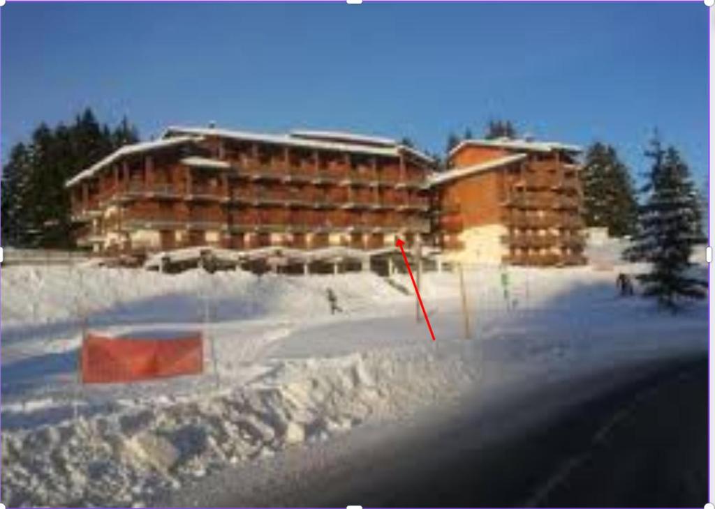 un grand bâtiment dans la neige à côté d'une route dans l'établissement Appartement 5 personnes en station Savoie Grand Revard, à Trévignin