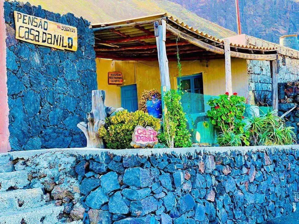 una casa con un cartel en una pared de piedra en Pensão CasaDanilo en Portela