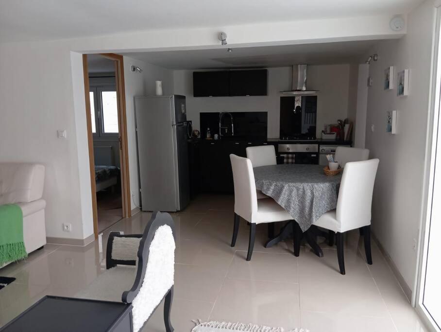 eine Küche und ein Esszimmer mit einem Tisch und Stühlen in der Unterkunft Appartement Cosy avec Jardin in Vaux-sur-Seine
